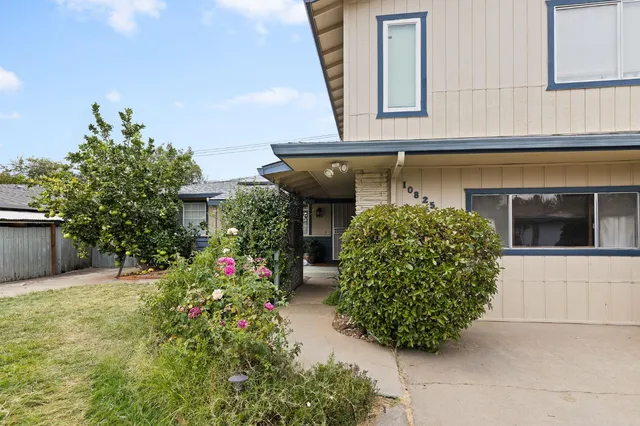 a front view of a house with plants