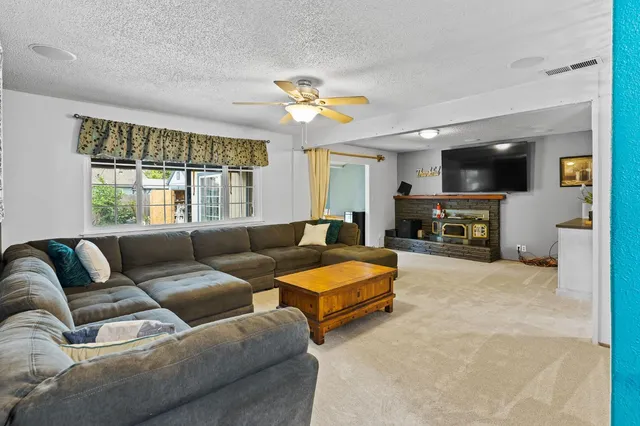 a living room with furniture a flat screen tv and a large window