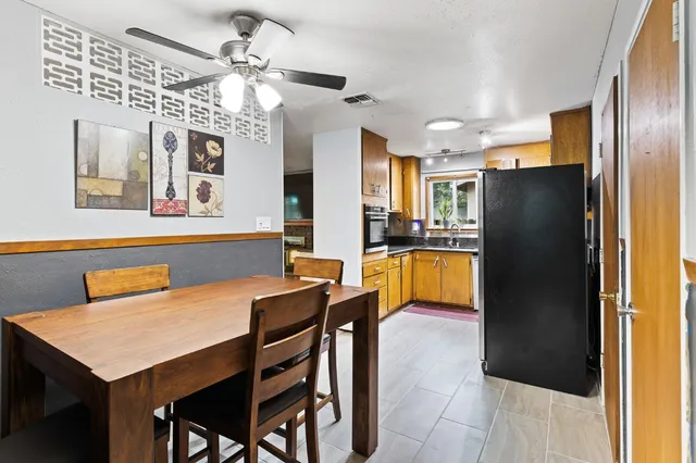 a kitchen with stainless steel appliances kitchen island granite countertop a refrigerator a stove a sink dishwasher with a dining table and chairs