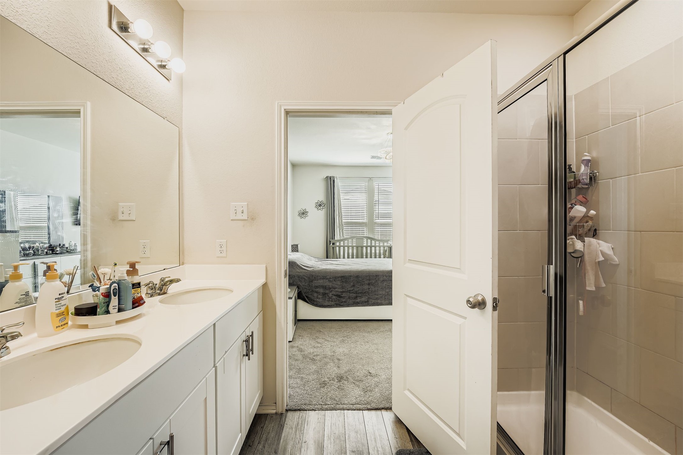 144 Gunther Way Taylor, TX 76574 - Photo 15 of 29 a en suite bathroom with a double vanity sink a mirror and a shower