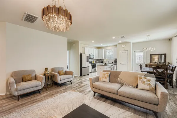 a living room with furniture and a chandelier