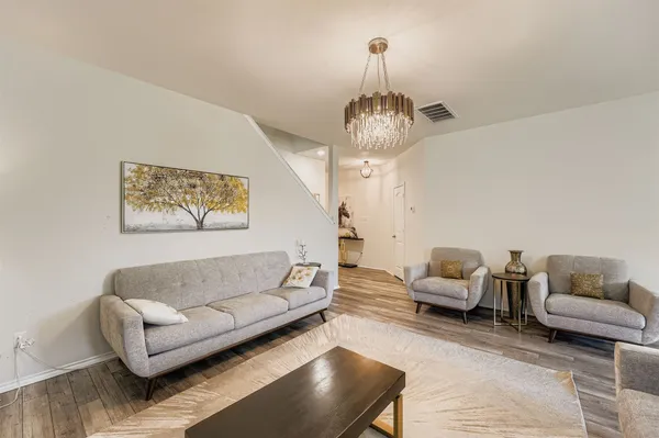 a living room with furniture and a chandelier