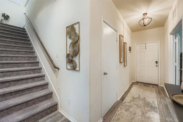 a view of a hallway with wooden floor and staircase