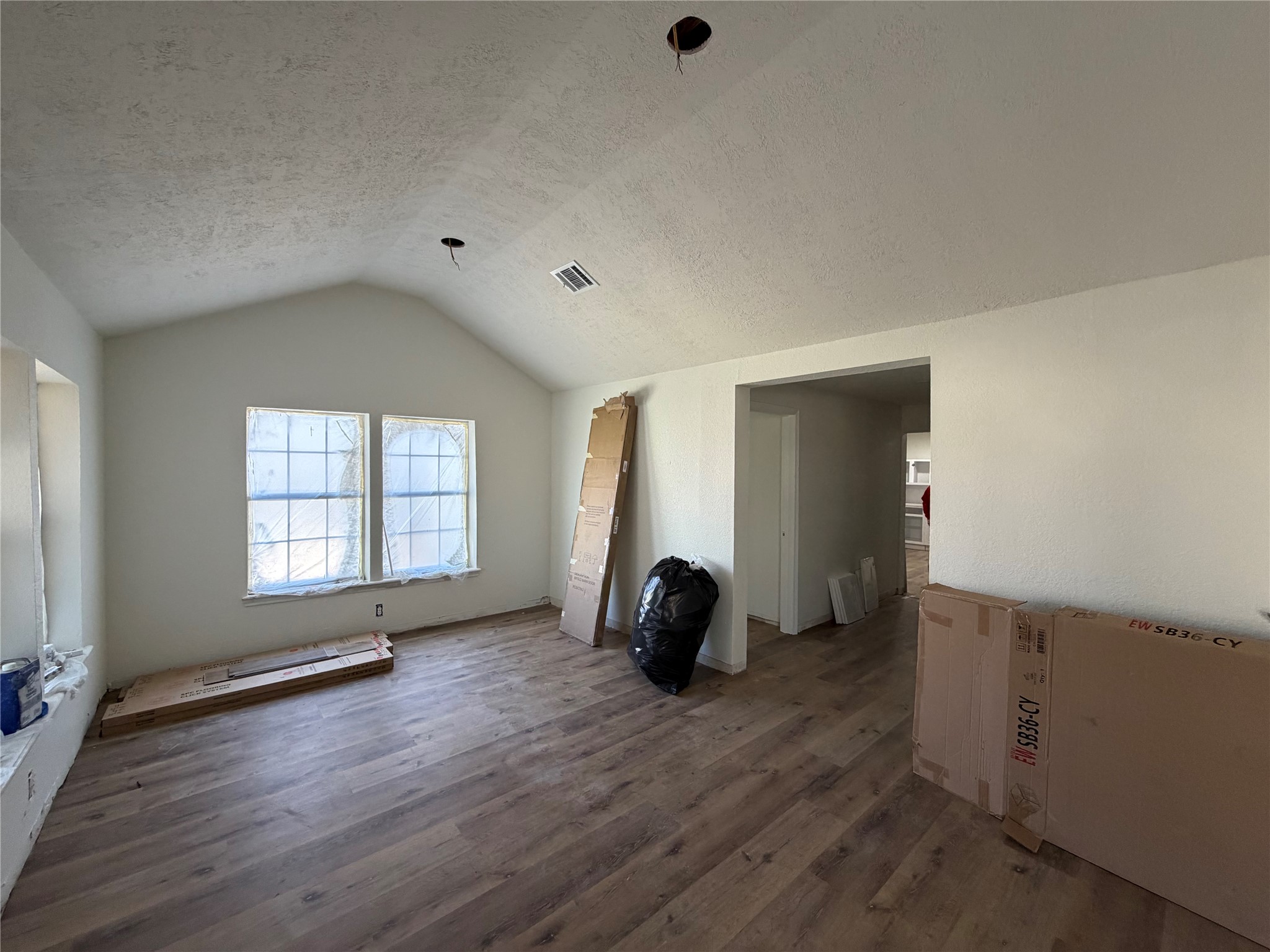 915 West Lewis Street Conroe, TX 77301 - Photo 2 of 6 an empty room with wooden floor and windows
