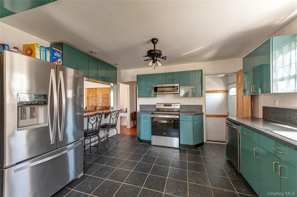 a kitchen with stainless steel appliances a refrigerator sink and microwave