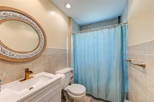 a bathroom with a sink a toilet and a mirror