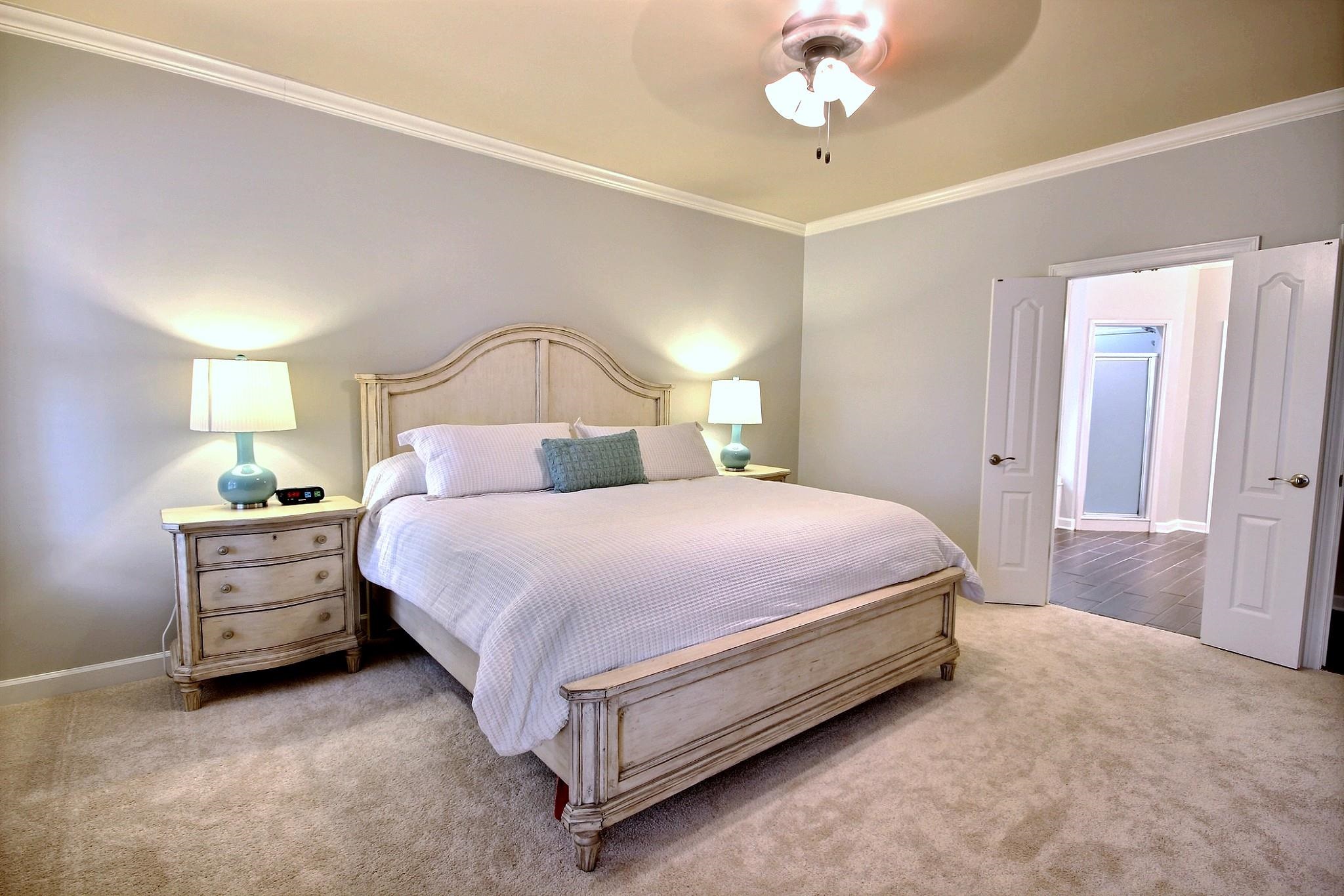 1050 Stanhope Road Collierville, TN 38017 - Photo 16 of 31 a spacious bedroom with a bed and a chandelier