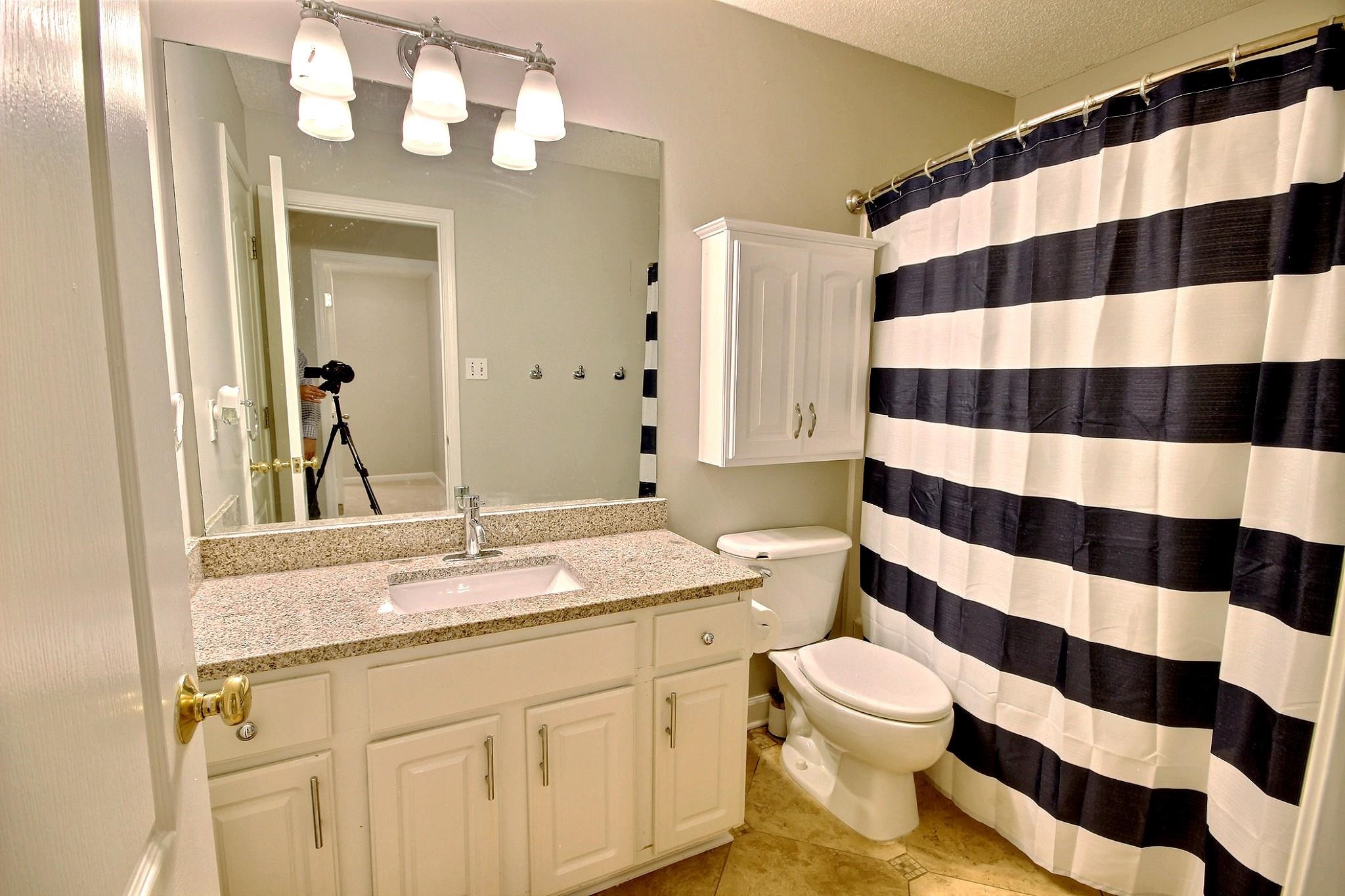 1050 Stanhope Road Collierville, TN 38017 - Photo 23 of 31 a bathroom with a sink a toilet a mirror and shower