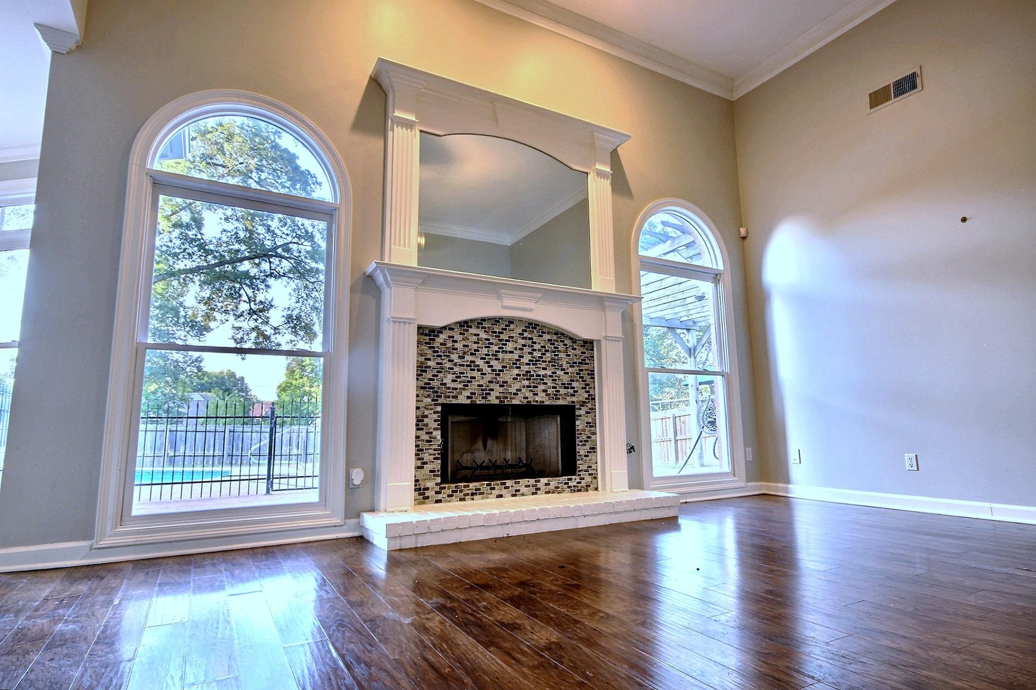 1050 Stanhope Road Collierville, TN 38017 - Photo 5 of 31 a view of an empty room with wooden floor fireplace and a window