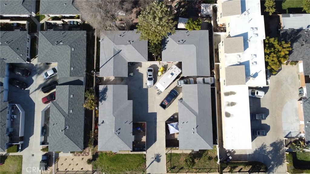 an aerial view of residential houses with outdoor space and parking