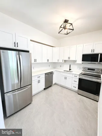 a kitchen with stainless steel appliances a refrigerator sink and microwave