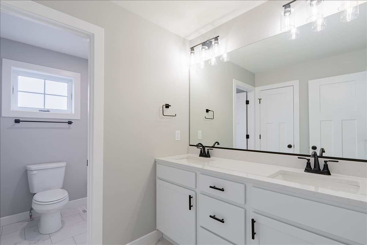 5206 Finlen Lane Bloomington, IL 61705 - Photo 21 of 40 a bathroom with a sink a toilet and a mirror