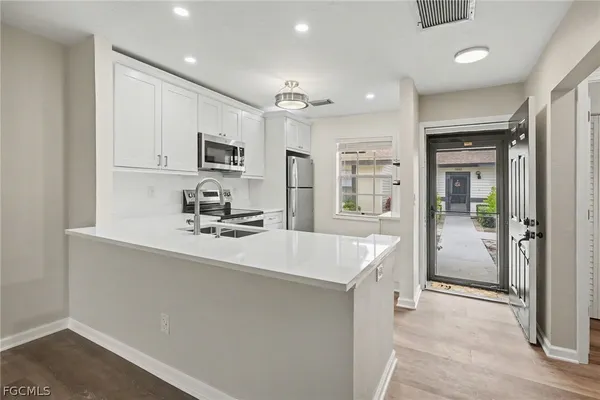 a kitchen with kitchen island a sink stainless steel appliances and cabinets