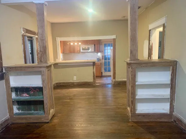 a view of a hallway with wooden floor and a fireplace