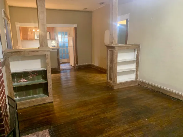 a view of empty room with wooden floor