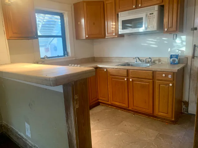 a kitchen with stainless steel appliances granite countertop a sink and a microwave