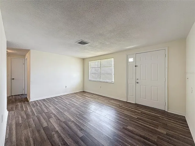 a view of an empty room and wooden floor