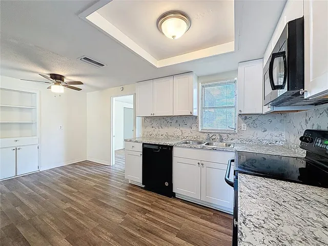 a kitchen with a stove sink and cabinets