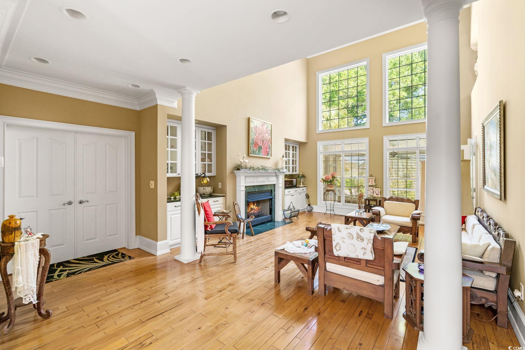 Living area with ornate columns, light wood-style