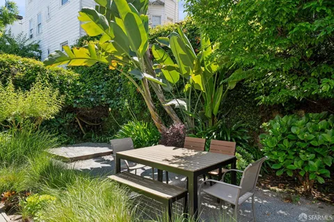a view of a chair and table in backyard of the house