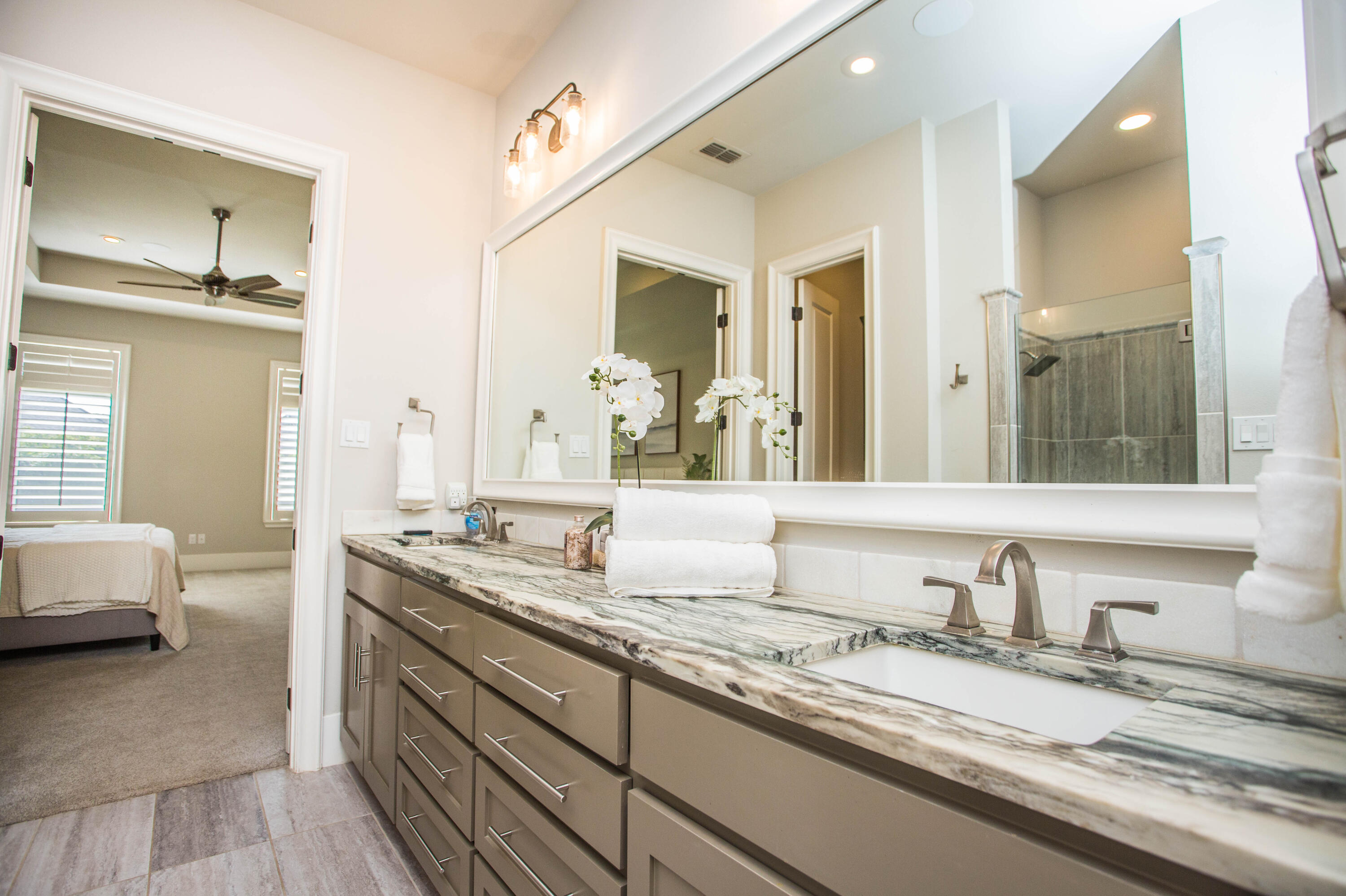 4807 116th Street Lubbock, TX 79424 - Photo 25 of 51 a en suite bathroom with a granite countertop sink and a mirror