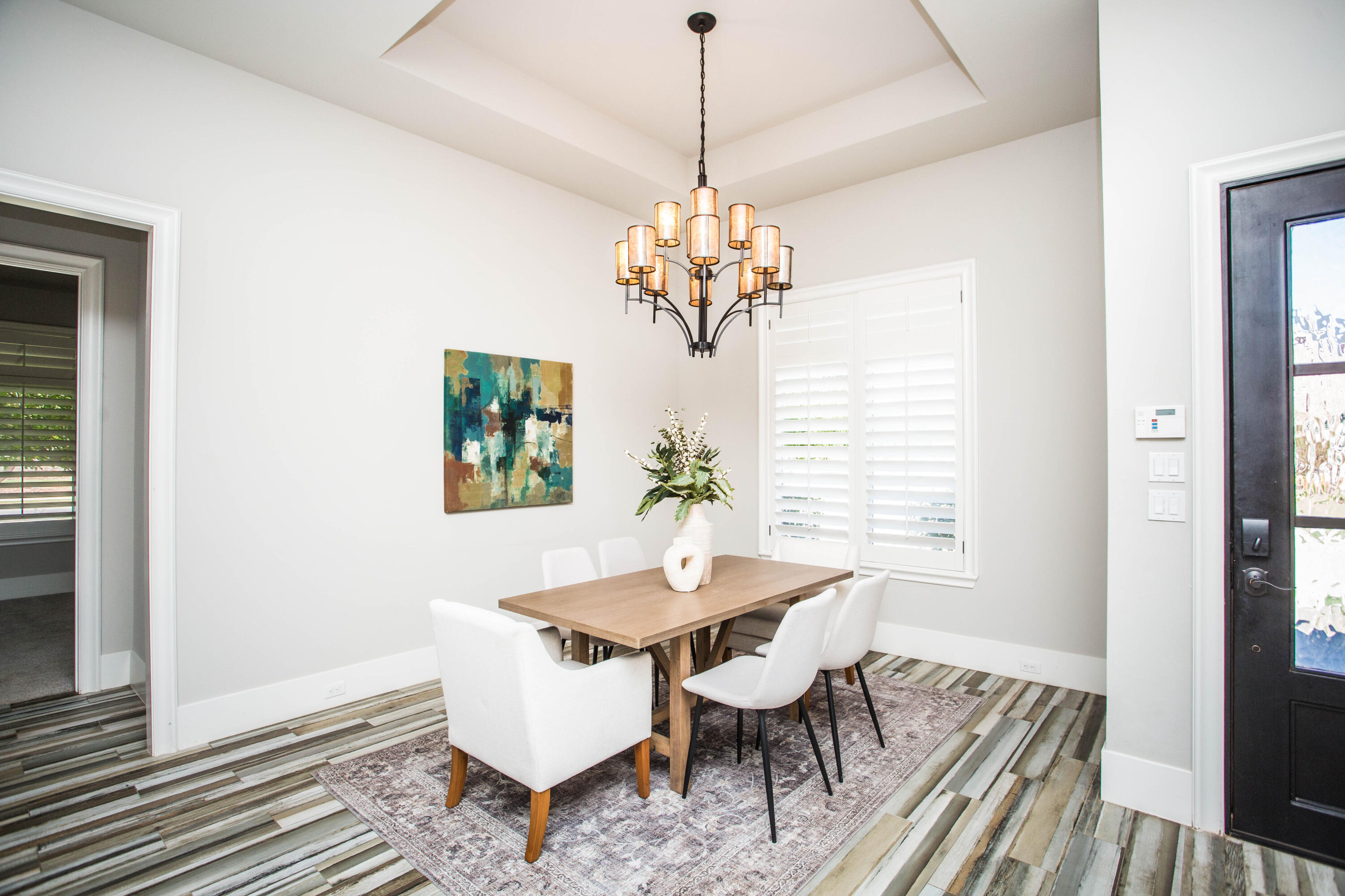 4807 116th Street Lubbock, TX 79424 - Photo 5 of 51 a dining room with wooden floor a chandelier a wooden table and chairs