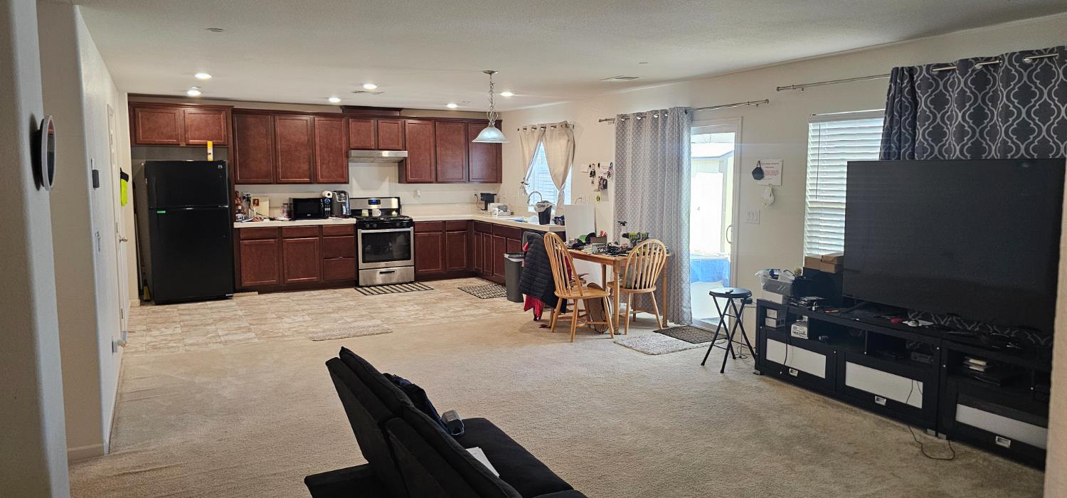 9290 Brock Court Live Oak, CA 95953 - Photo 2 of 29 a kitchen with a refrigerator and a dining table