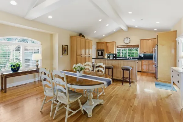 a kitchen with a stove and wooden floor