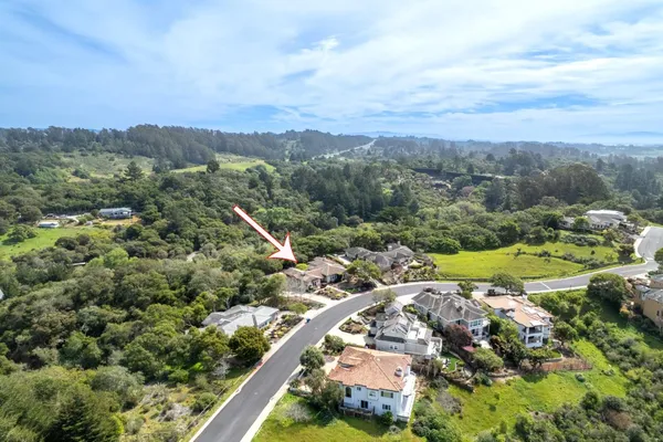 an aerial view of a house with a yard and parking