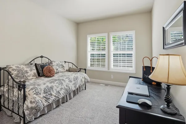 a spacious bedroom with a bed and a dresser