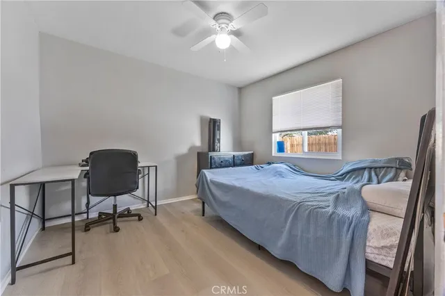 a bedroom with a bed chairs and a potted plant