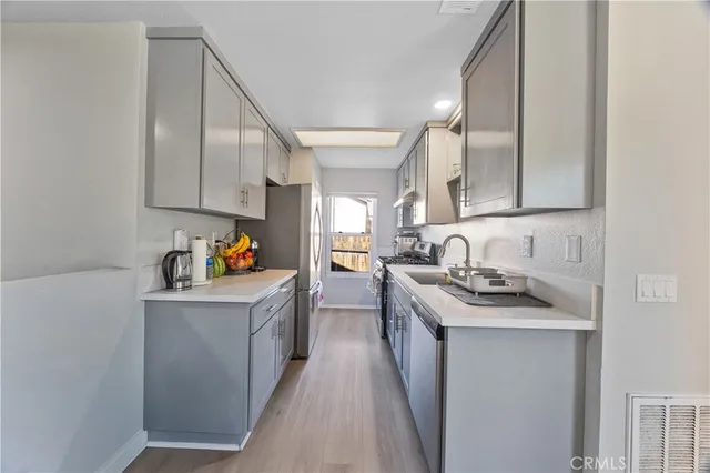 a kitchen with stainless steel appliances granite countertop a sink stove and cabinets