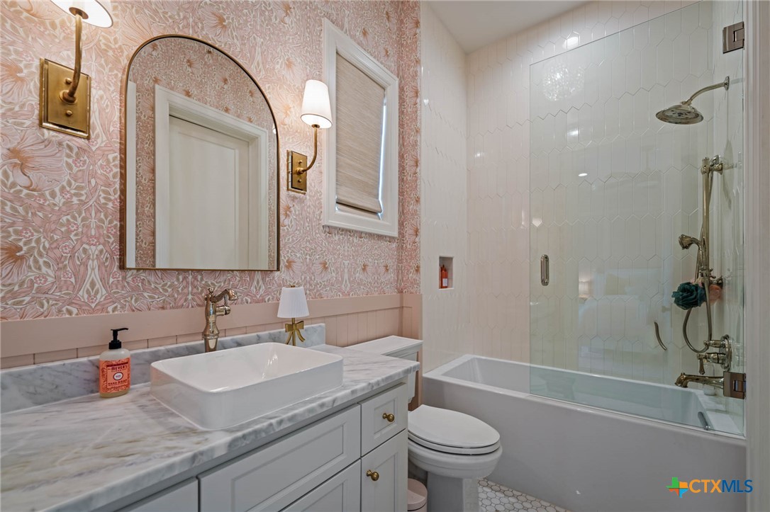 1755 Riada Drive New Braunfels, TX 78132 - Photo 24 of 48 a bathroom with a granite countertop sink a toilet and bathtub