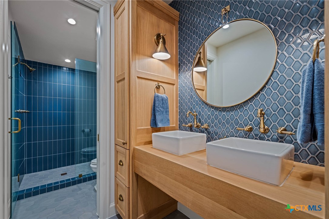 1755 Riada Drive New Braunfels, TX 78132 - Photo 34 of 48 a bathroom with a double vanity sink and a mirror