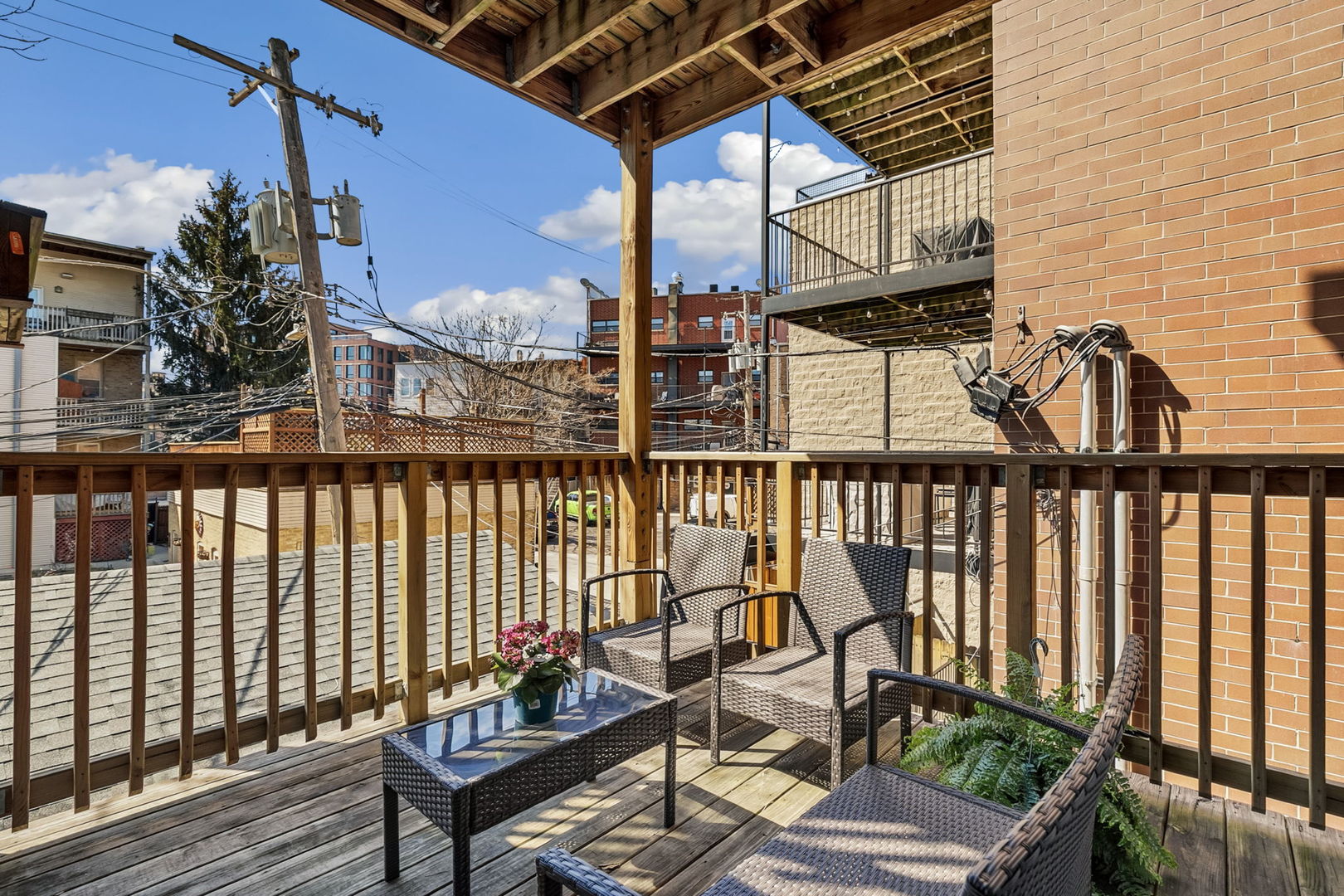 909 West Roscoe Street, Unit 2 Chicago, IL 60657 - Photo 20 of 22 a balcony of a house with wooden floor outdoor seating and yard in the back