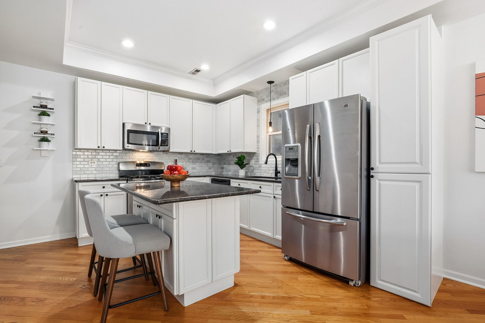 909 West Roscoe Street, Unit 2 Chicago, IL 60657 - Photo 8 of 22 a kitchen with stainless steel appliances a refrigerator stove microwave and cabinets