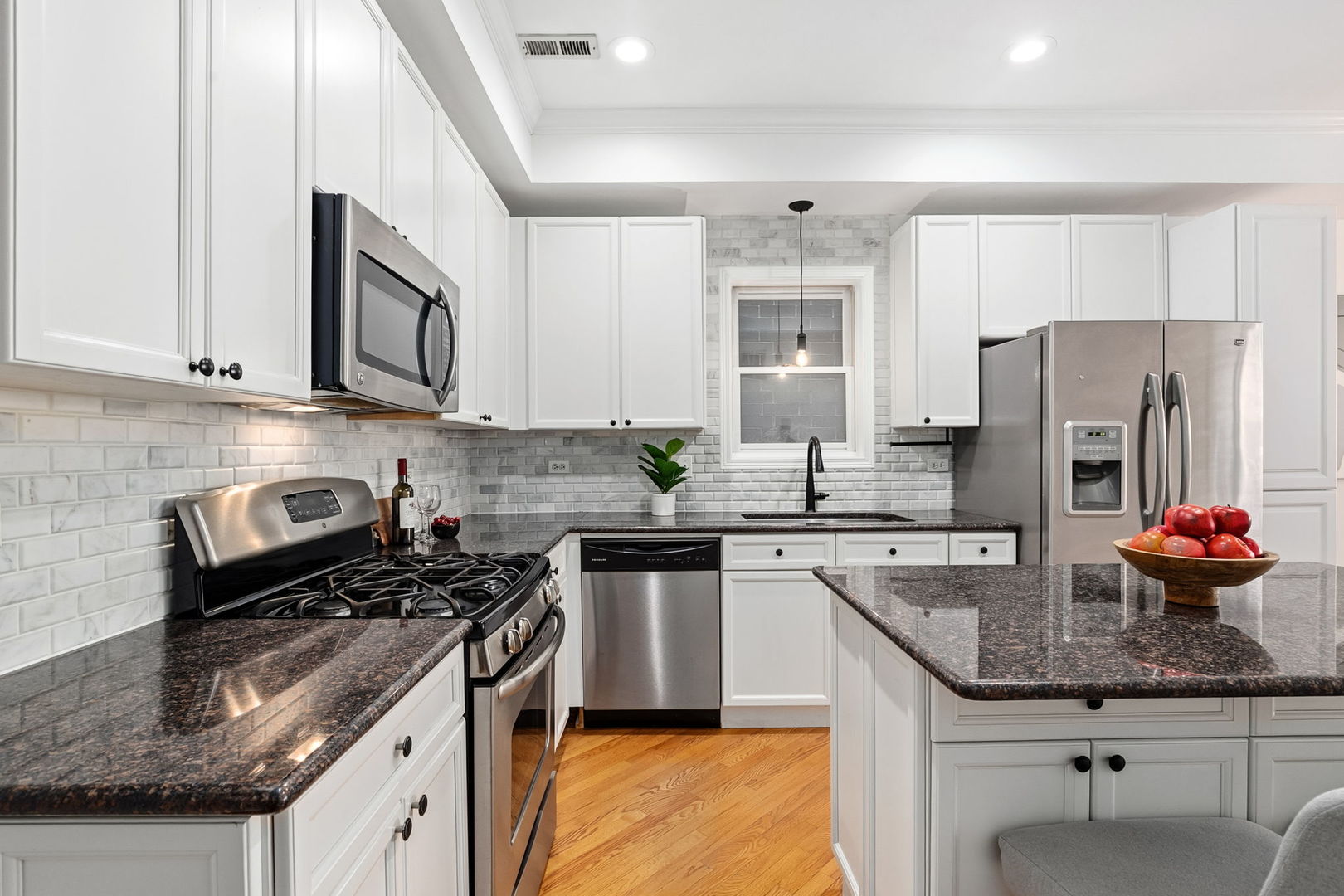 909 West Roscoe Street, Unit 2 Chicago, IL 60657 - Photo 9 of 22 a kitchen with stainless steel appliances granite countertop a sink stove and refrigerator