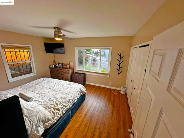 a bedroom with a bed and a dresser next to a window