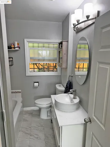 a bathroom with a toilet a sink and mirror