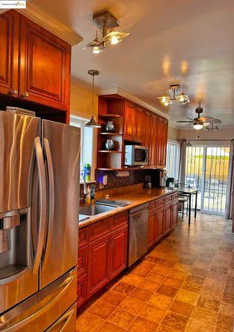 a kitchen with stainless steel appliances granite countertop a refrigerator and a sink