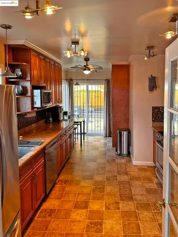 a large hall with stainless steel appliances granite countertop a refrigerator and a sink