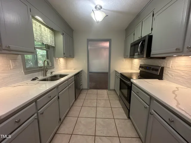 a kitchen with a sink a stove and cabinets