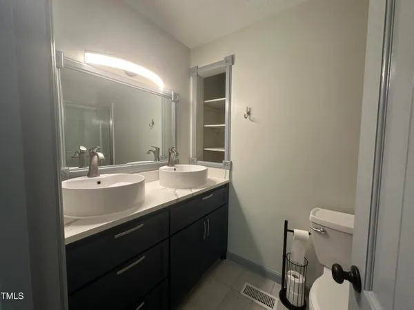 a bathroom with a granite countertop sink a toilet and a mirror