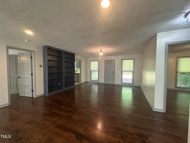 an empty room with wooden floor and closet