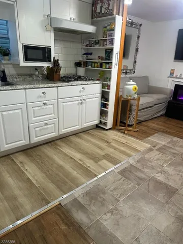 a view of a kitchen with wooden floor and a sink