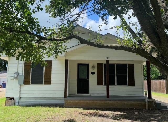 440 Rigsby Street Van Alstyne, TX 75495 - Photo 2 of 7 White siding exterior with a dark front door, accented by dark window shutters