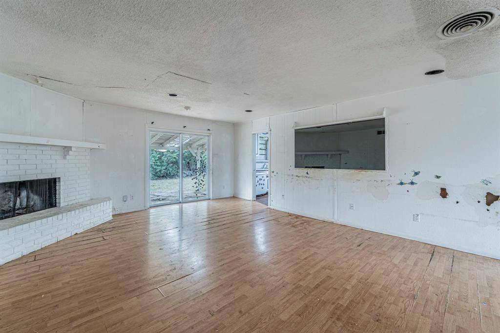 3816 Springbranch Drive Benbrook, TX 76116 - Photo 5 of 27 a view of an empty room with wooden floor and a fireplace