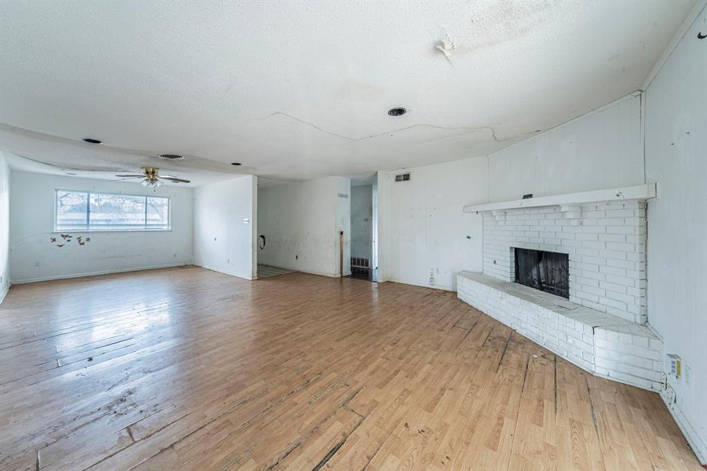 3816 Springbranch Drive Benbrook, TX 76116 - Photo 7 of 27 an empty room with wooden floor and fireplace