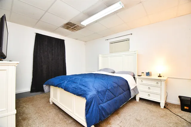 a bedroom with bed and a baby crib