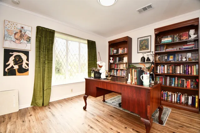 a view of a workspace with furniture and a bookshelf